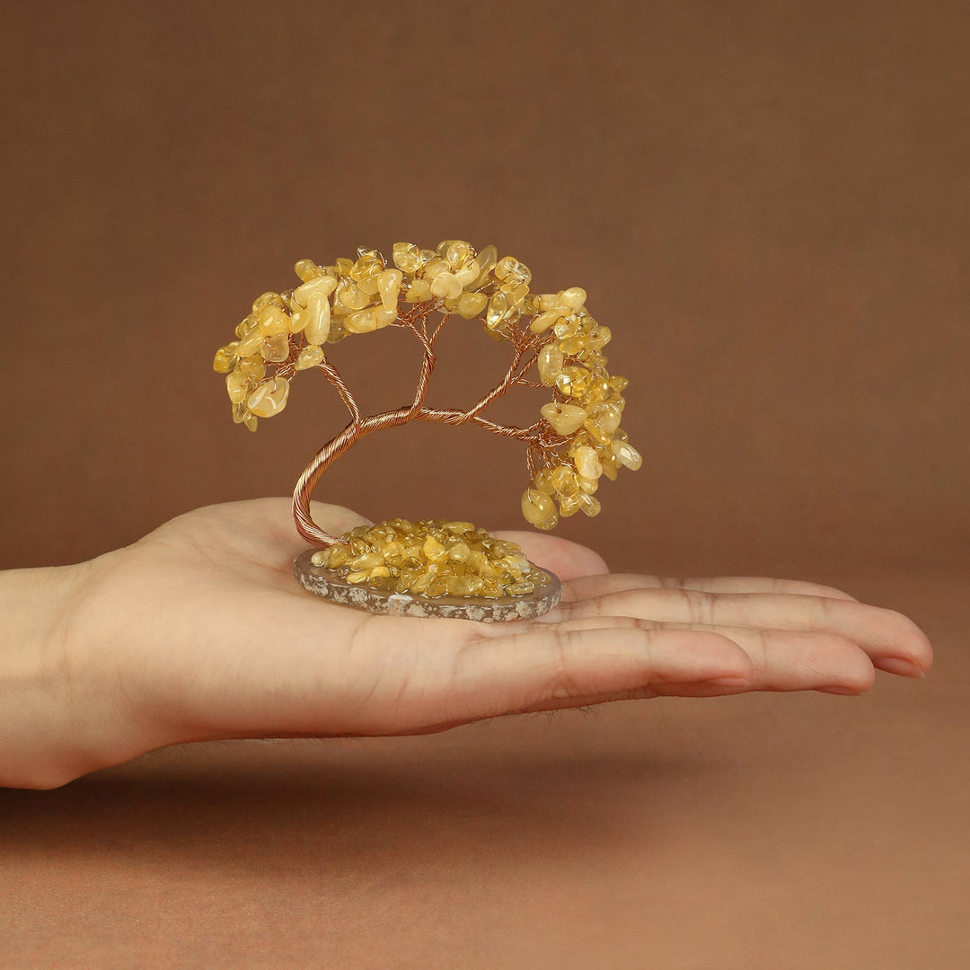 Yellow beaded crystal tree ornament with copper wire branches on a stone base