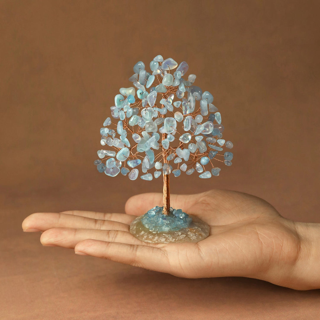 Light blue crystal tree figurine with clustered stones on a circular base and thin trunk