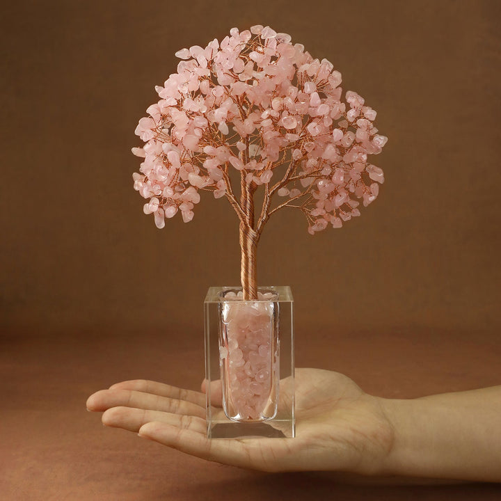 Pink crystal tree with faceted stone branches in a clear cube base