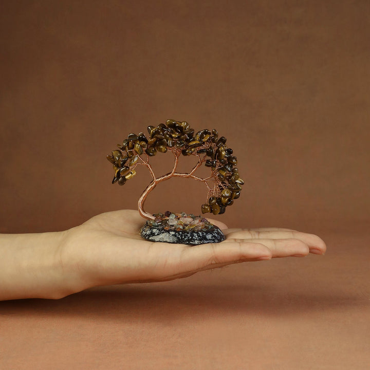 Gold-brown beaded crystal tree ornament with copper wire branches on a stone base