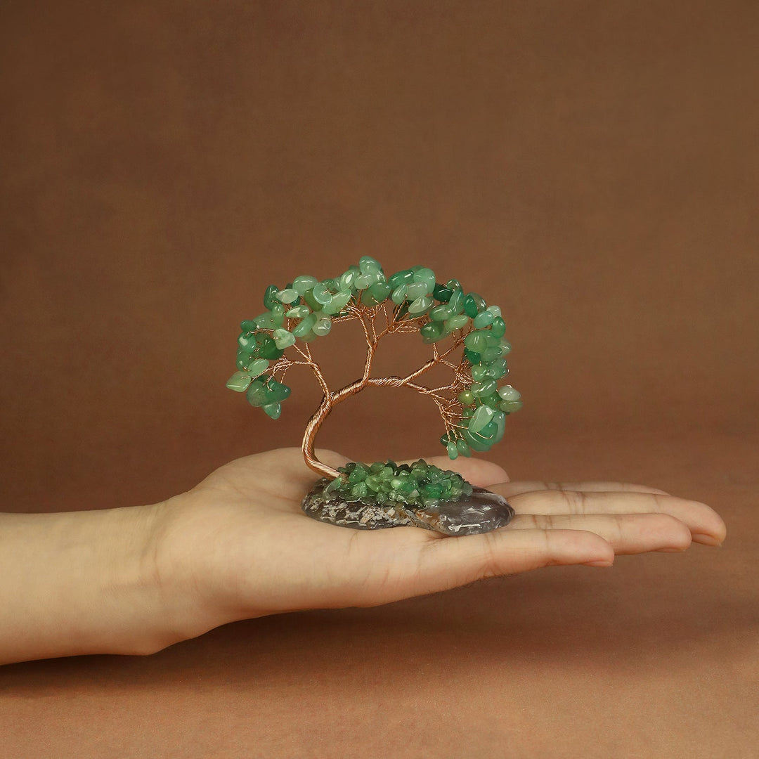 Green beaded crystal tree ornament with copper wire branches on a stone base