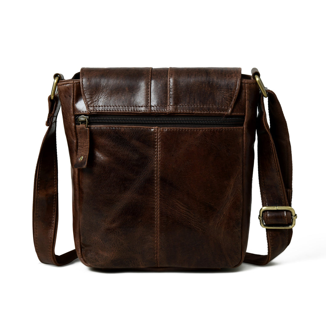 Brown leather messenger bag with front flap, top zipper pocket, and side strap buckles