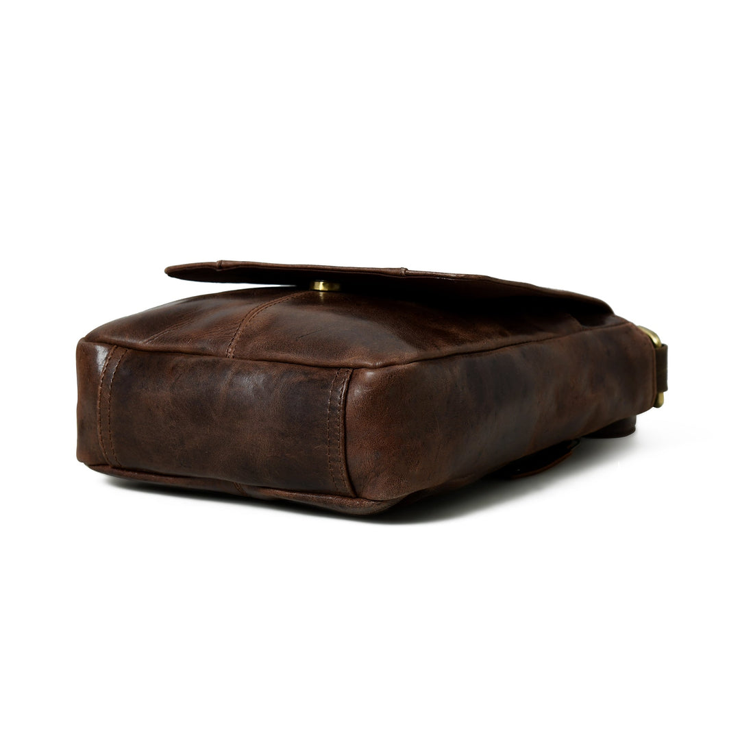 Brown leather messenger bag side and bottom view with low-profile shape and strap hardware