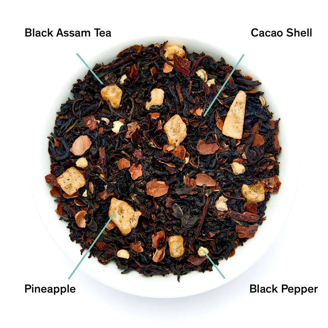 Black tea leaves with pineapple chunks and spices in a tea bowl