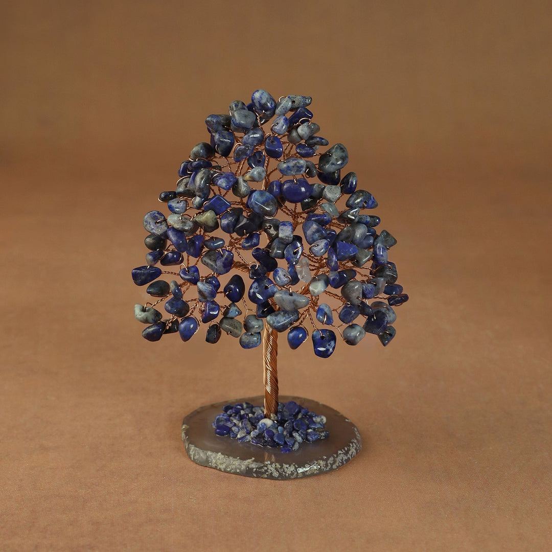 Rooted crystal tree with blue lapis lazuli chips on a round stone base