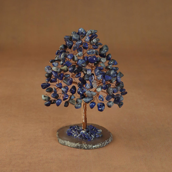 Rooted crystal tree with blue lapis lazuli chips on a round stone base