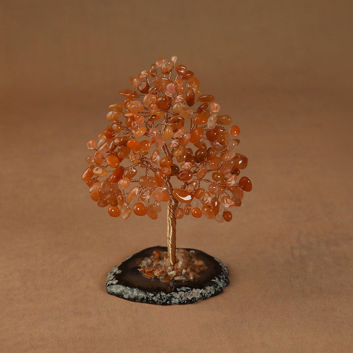 Rooted crystal tree with orange carnelian chips on a round stone base