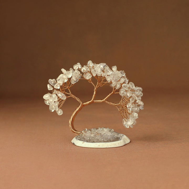 Clear gemstone crystal tree with wire branches and chips on a white stone base