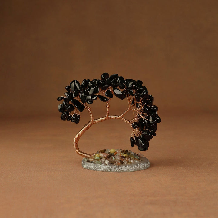 Black beaded crystal tree ornament with copper wire branches and a round stone base
