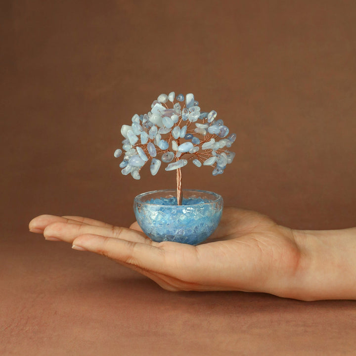 Light blue crystal tree ornament with gem-like branches in blue glass bowl