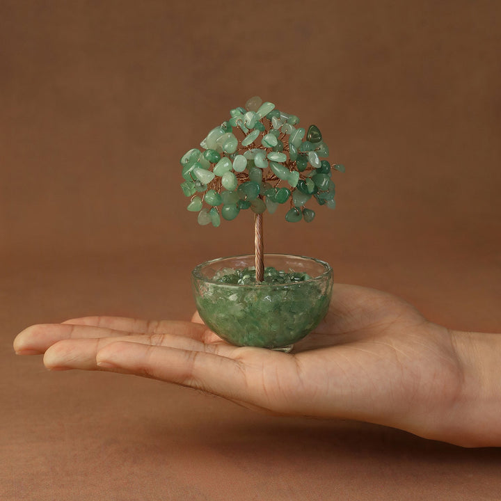 Green crystal gemstone tree with beaded canopy in a tinted resin bowl, held in hand