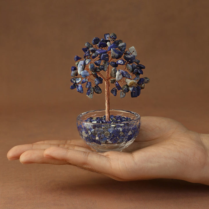 Blue crystal tree ornament with gem-like branches in clear glass bowl