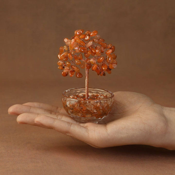 Orange crystal gemstone tree with beaded canopy in a tinted resin bowl, held in hand