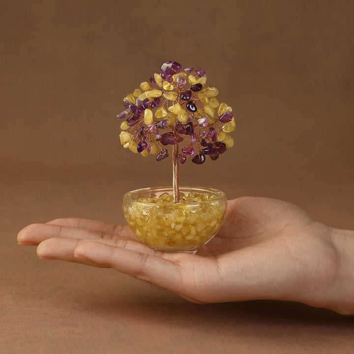 Yellow and purple crystal tree ornament with gem-like branches in glass bowl