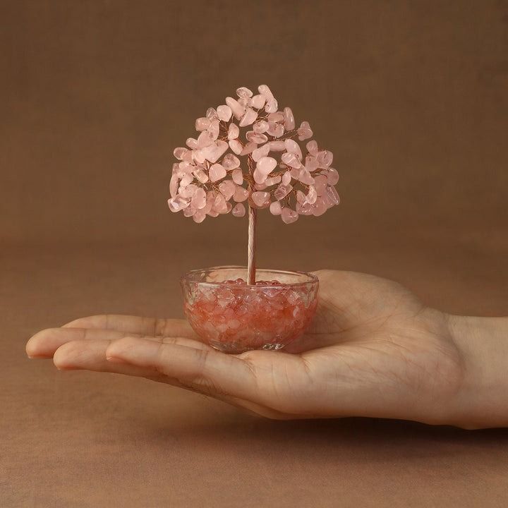 Pink crystal gemstone tree with beaded canopy in a tinted resin bowl, held in hand