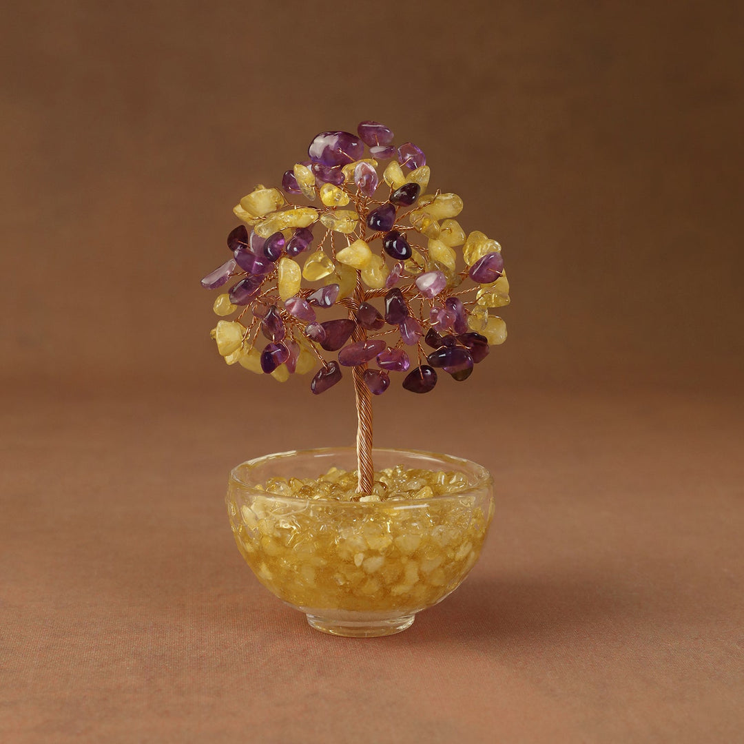 Yellow and purple crystal tree ornament with beaded branches in a clear glass bowl