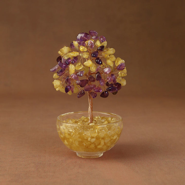 Yellow and purple crystal tree ornament with beaded branches in a clear glass bowl