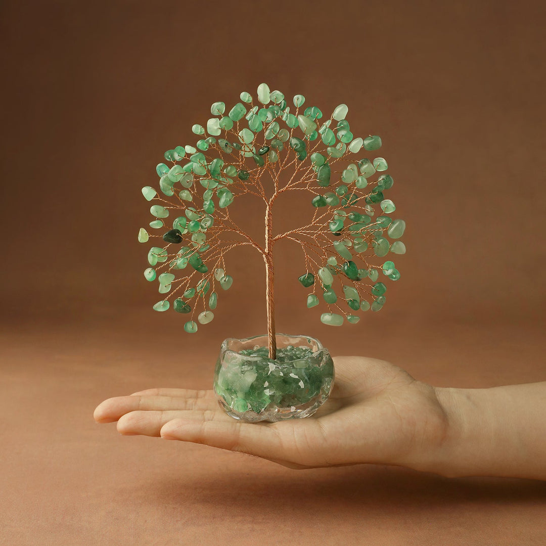 Green crystal chakra tree with wire branches on clear stone base, held in hand