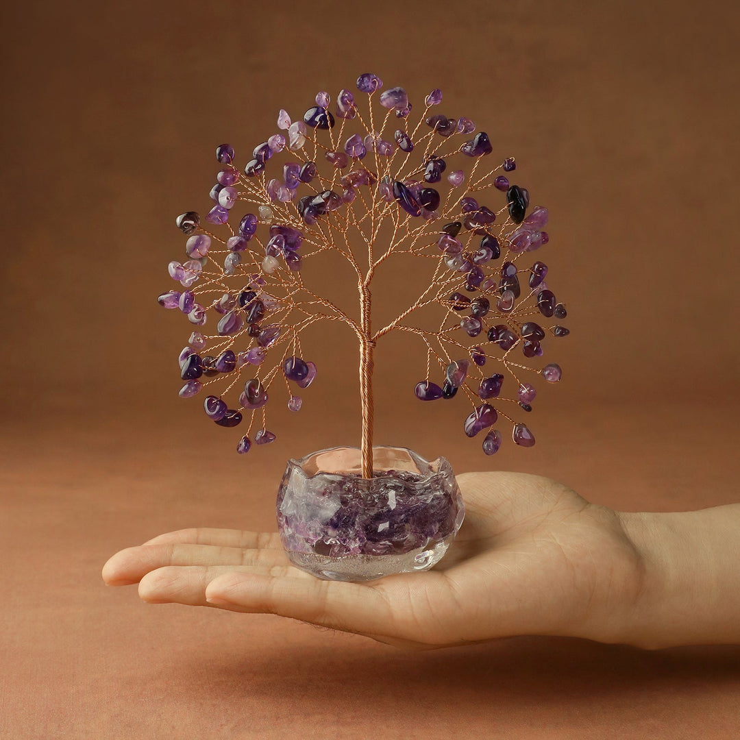 Purple amethyst gemstone crystal tree in a crystal bowl base held in hand