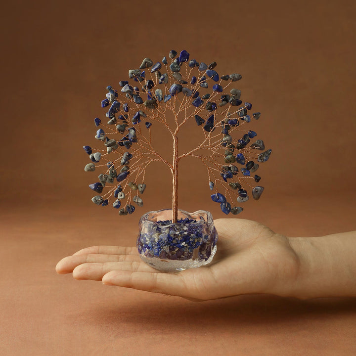 Blue crystal tree with wire branches on blue stone base, held in hand