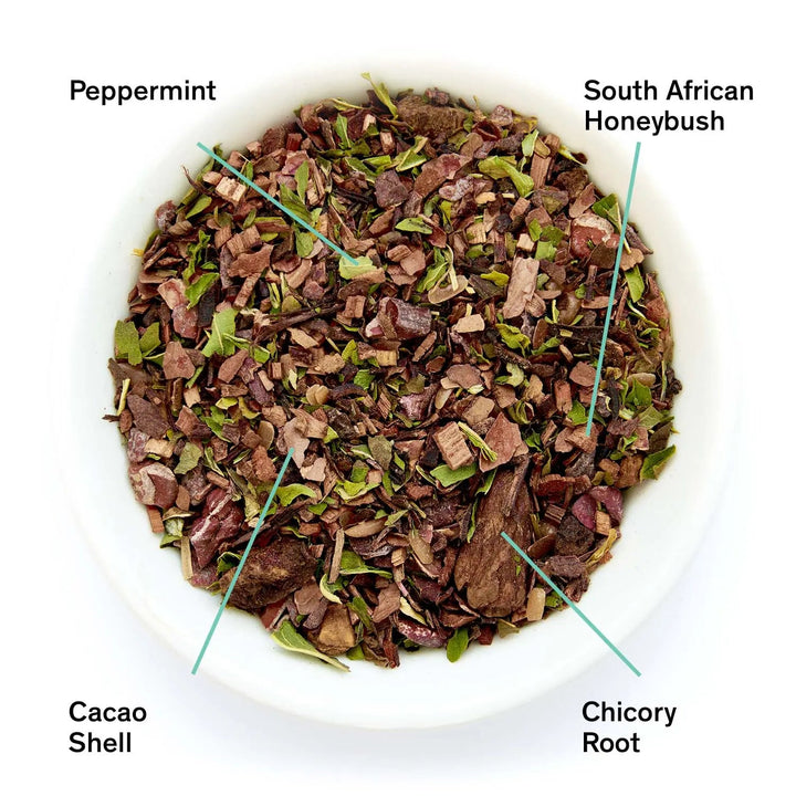 Loose herbal tea leaf mix in bowl with peppermint, honeybush, cacao shell, and chicory root