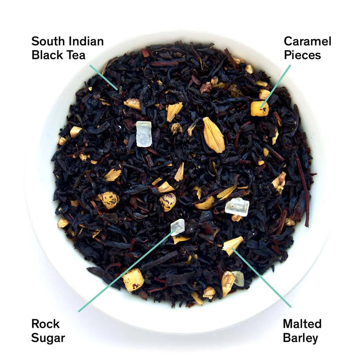Plate of dark black tea leaves with scattered caramel and sugar pieces
