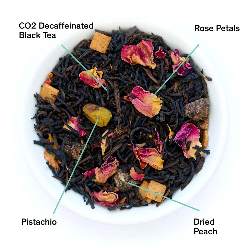 Loose black tea blend with rose petals, dried peach pieces, and pistachio bits