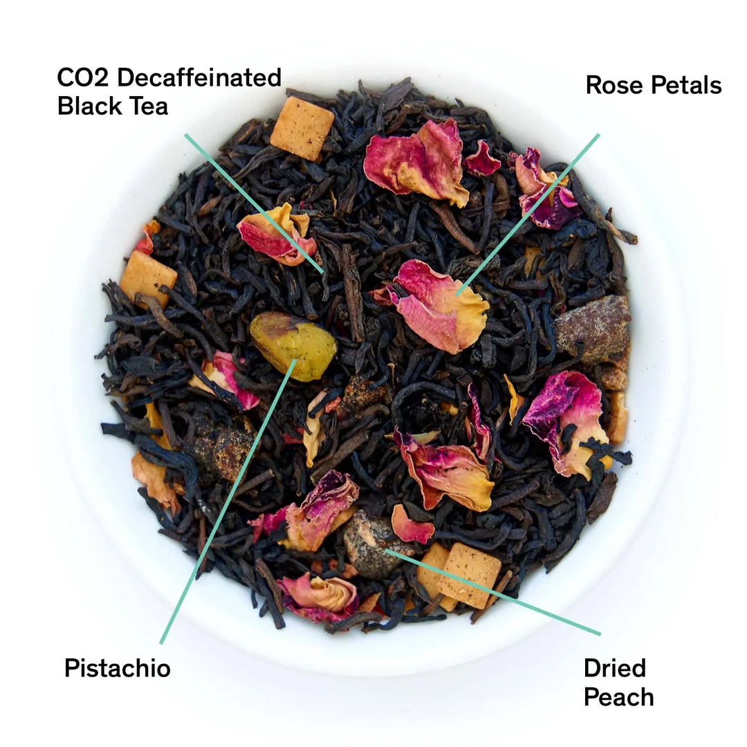 Loose black tea blend with rose petals, dried peach pieces, and pistachio bits