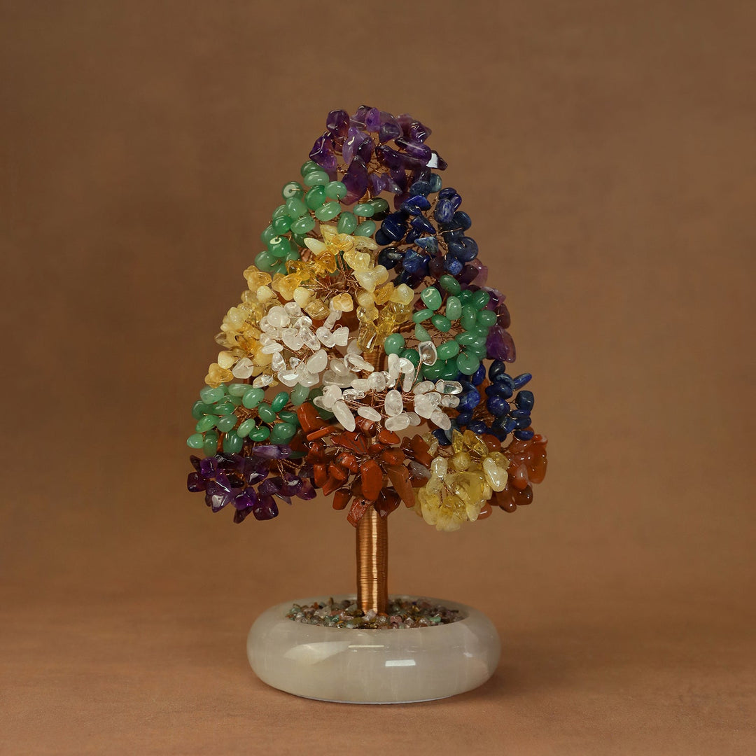 Crystal tree ornament with purple top, green middle, and yellow-and-white lower crystals on a white base