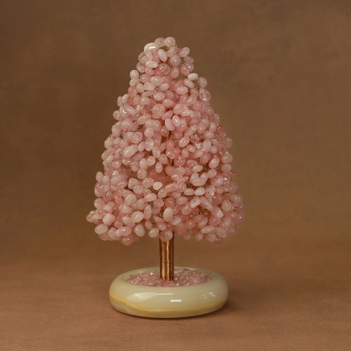 Pink crystal tree ornament with rounded crystal clusters on a pale yellow stone base