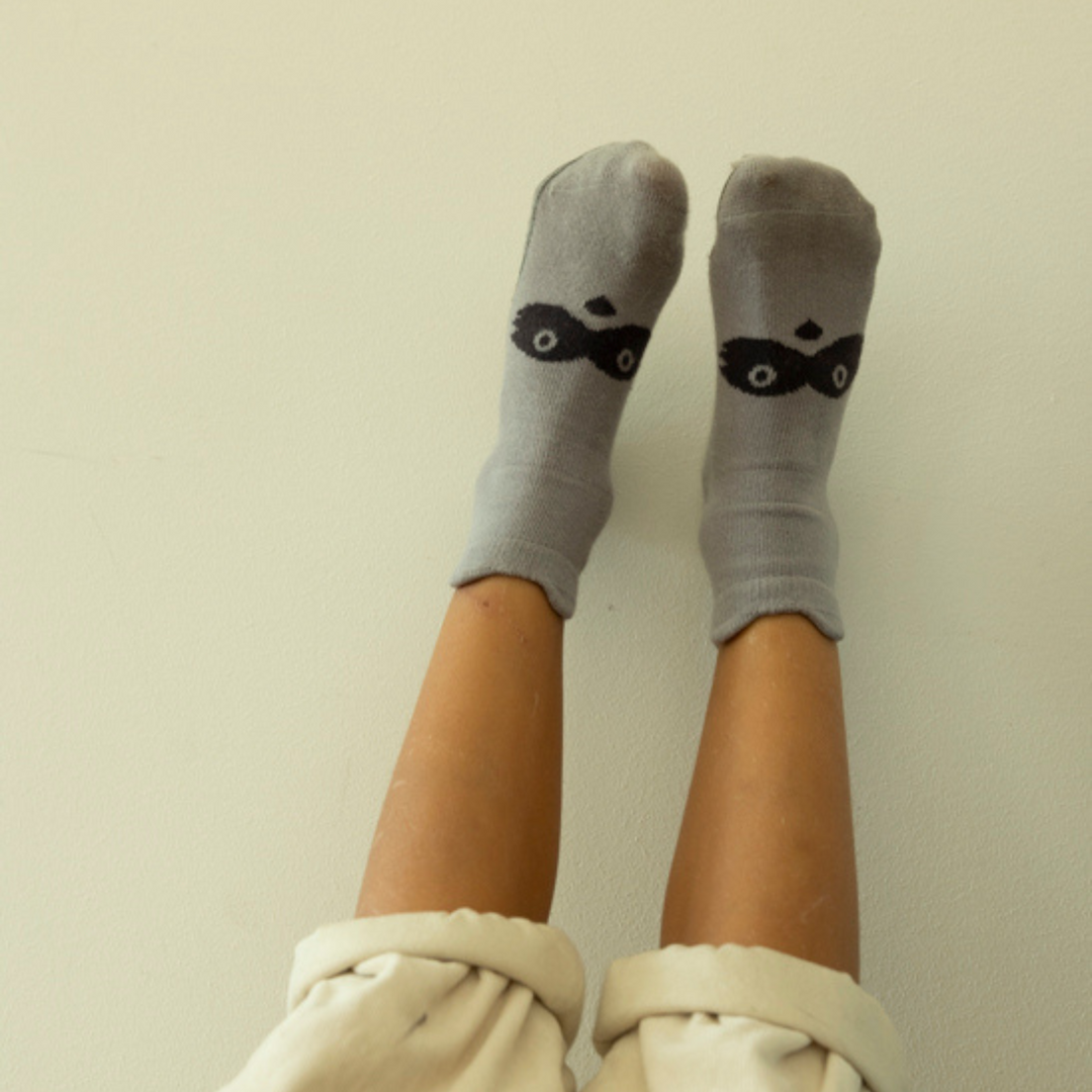 On-foot view: gray baby non-slip socks with small animal face print