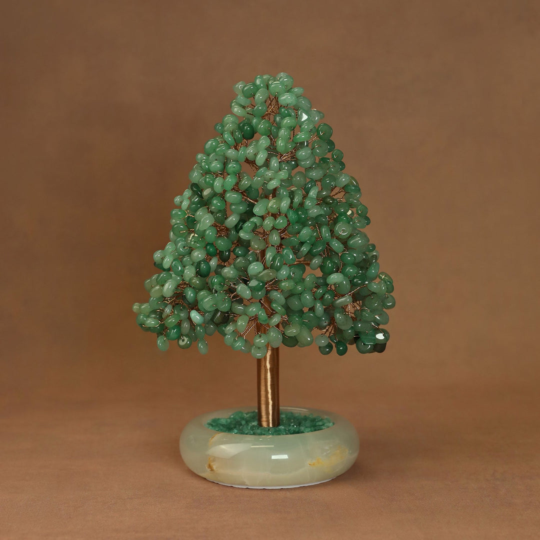 Green crystal tree ornament with clustered stones and gold-toned trunk on oval base