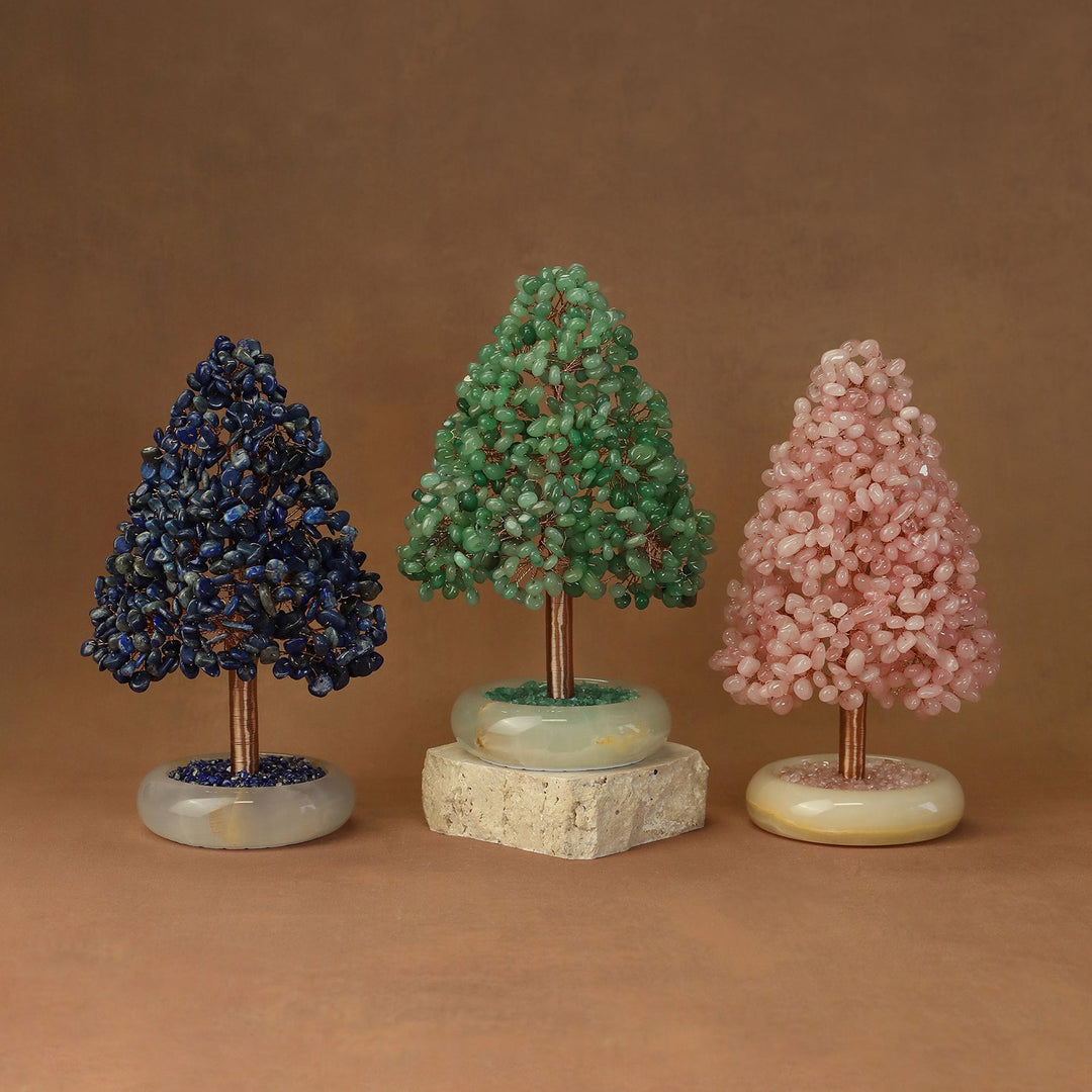 Three crystal tree ornaments with dark blue, green, and pink clusters on round stone bases