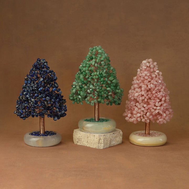 Three crystal tree ornaments with dark blue, green, and pink clusters on round stone bases