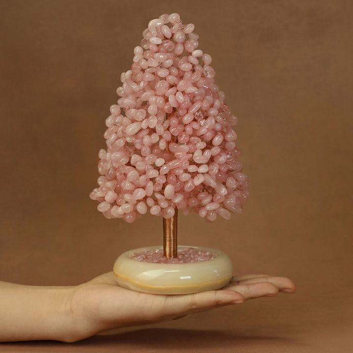 Pink crystal tree ornament with translucent stone clusters and gold-toned trunk on base