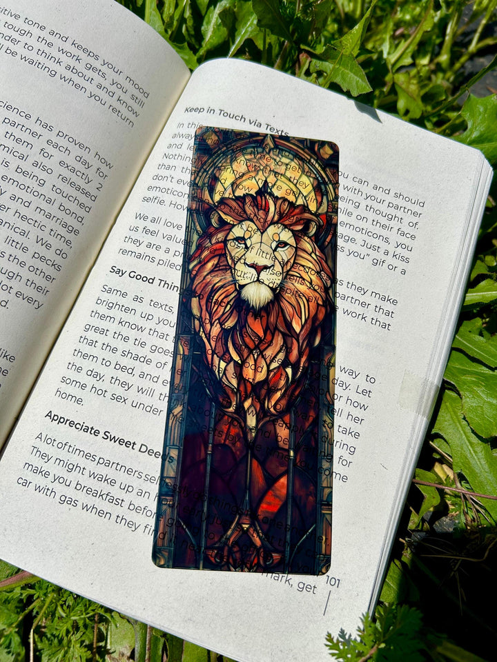Vertical lion stained-glass bookmark in open book, colorful mane with blue background