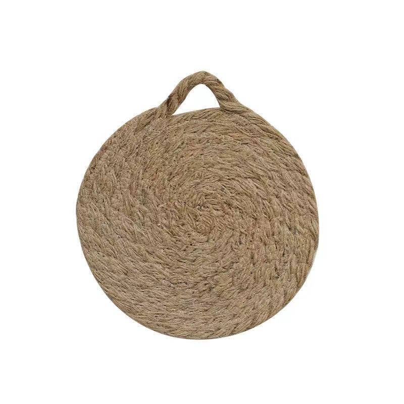 Round woven natural trivet with top handle loop, centered on white background