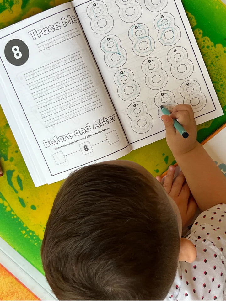 Open activity book page with large number 8 tracing lines and a child's hand