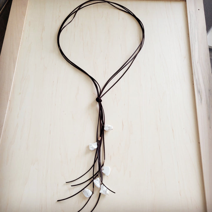 Dark brown cord necklace with knotted pendant and white pearl drop fringe