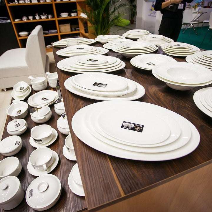 Set of white 10 in rolled-rim dinner plates stacked for service