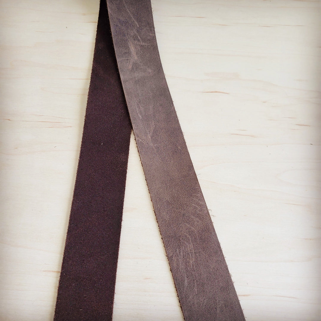 Brown distressed leather belt strap ends, flat with worn texture