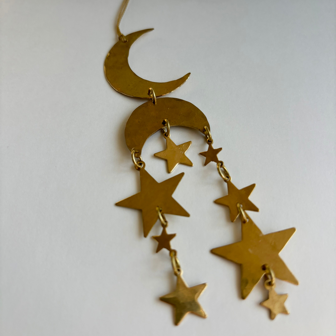 Gold crescent moon ornament with dangling star charms and small chain links
