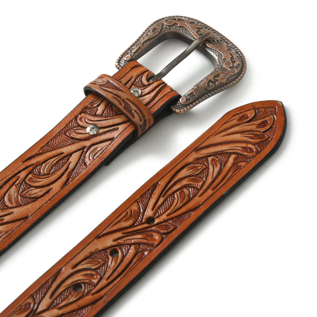 Cowboy belt close-up: carved tan leather with silver-toned metal buckle