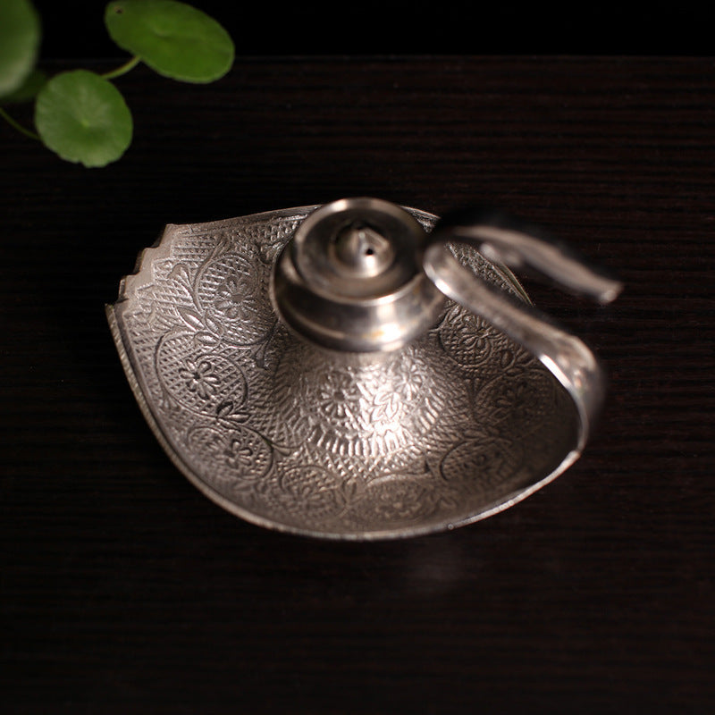Silver-toned engraved incense holder tray with central pot opening and handle curl