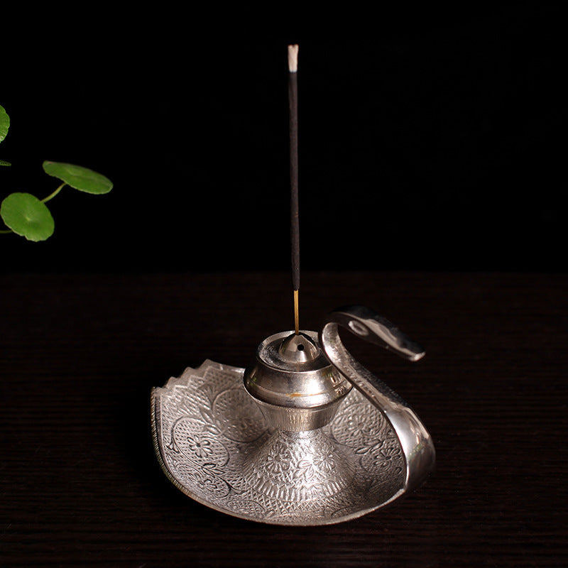 Silver-toned swan incense holder with upright incense stick and etched round tray