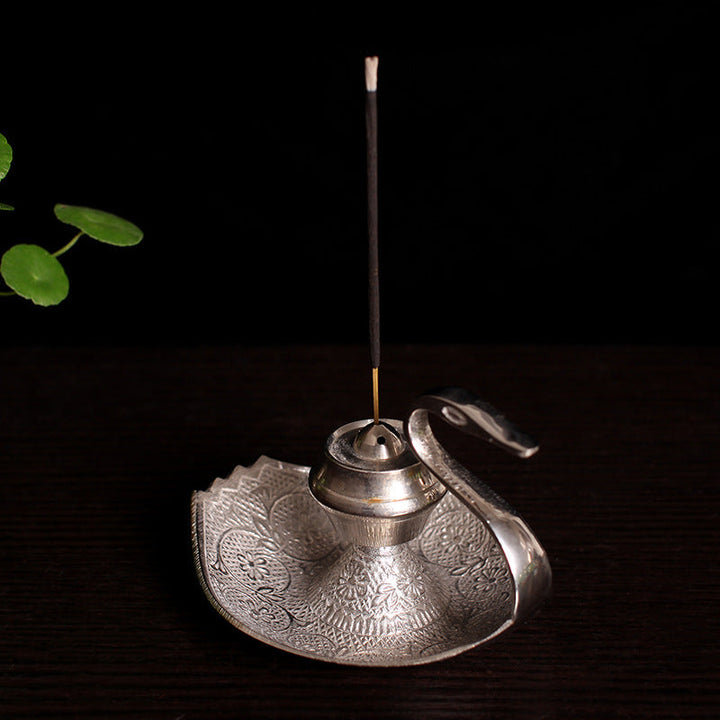 Silver-toned swan incense holder with upright incense stick and etched round tray