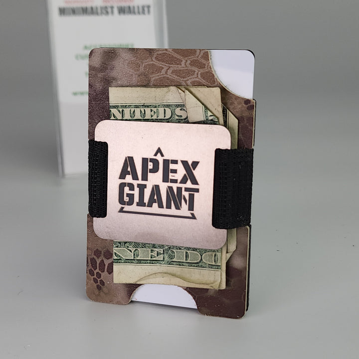 Minimalist camo wallet holding cash and cards, secured by black elastic band