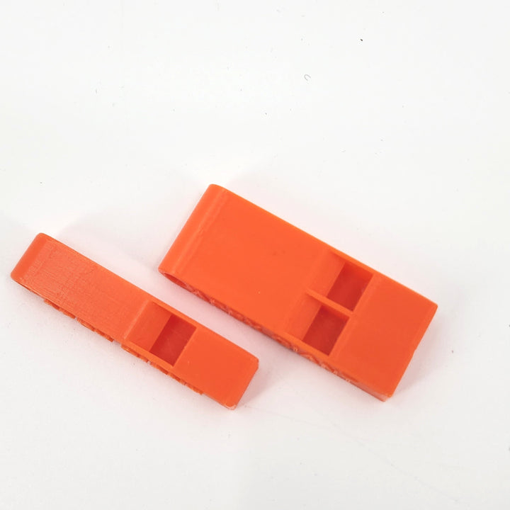 Orange plastic emergency whistles with vented ends and APEX GIANT molded text