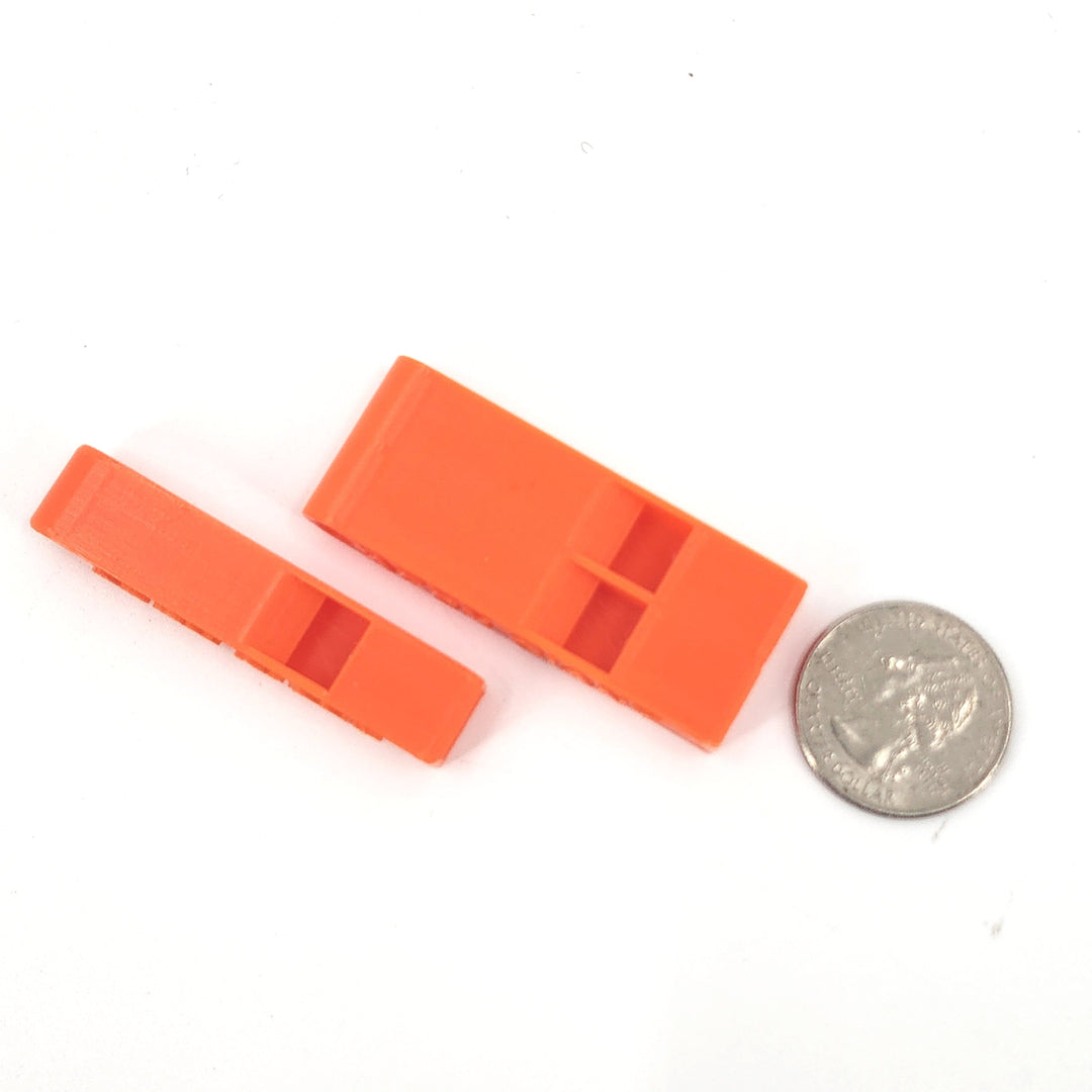 Orange plastic emergency whistle pair with open end and APEX GIANT, with coin for scale