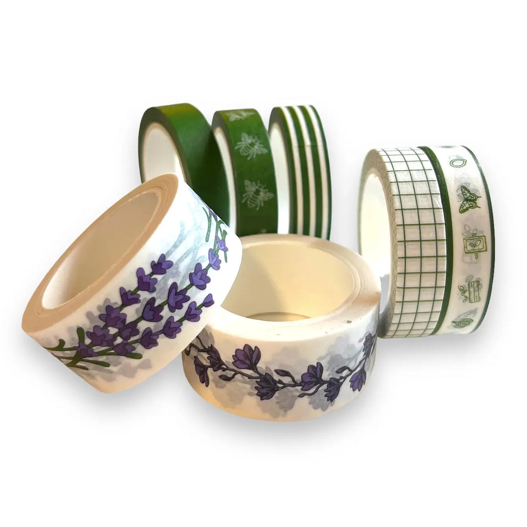 Washi tape rolls close-up: green stripes, grid, and purple floral branch patterns